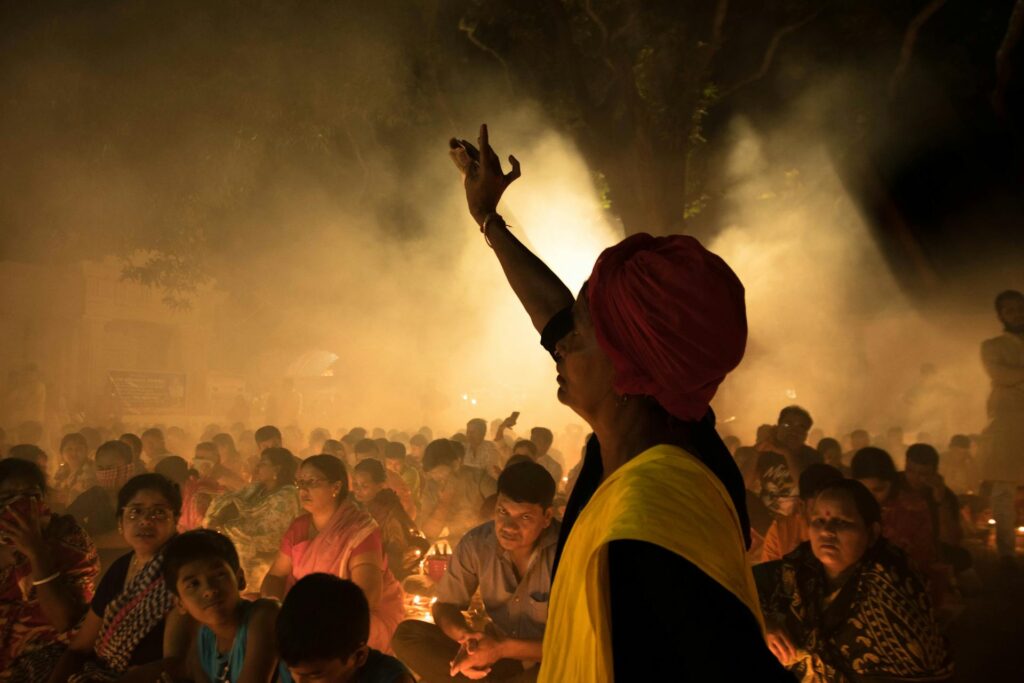 Crowd of ethnic people on street during Indian religious festival at night.
