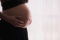 Pregnant woman in black holds her exposed stomach expectantly. Photo Source: RawPixel {CC0 1.0 DEED}