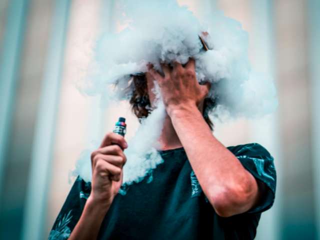 Selective Focus Photography Of Man Doing Vape Trick