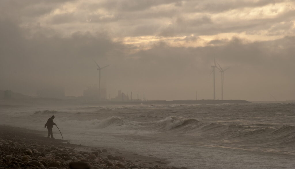 Photo of person walking near sea during noontime.