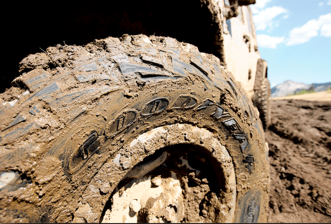 a mud-covered tire bearing the Goodyear logo
