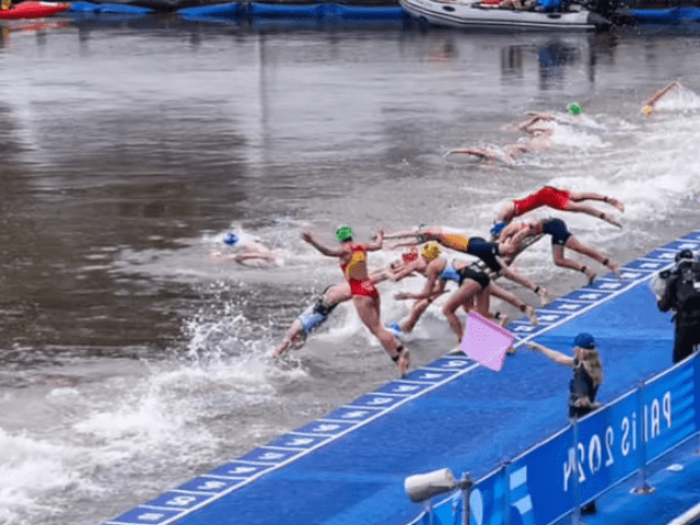 Athletes dive into the water at the start of a swimming event during the 2024 Summer Olympics in Paris. Photo Credits: @jacobsjasper @tzaferes @worldtriathlon (Instagram)