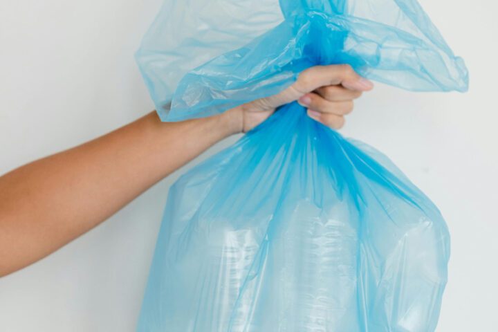 Close-Up Shot of a Person Holding a Blue Plastic Bag Photo Credits : Greta Hoffman