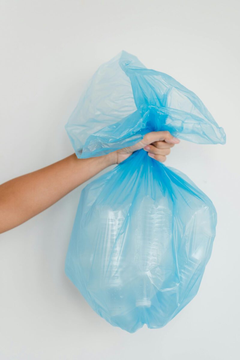 Close-Up Shot of a Person Holding a Blue Plastic Bag Photo Credits : Greta Hoffman