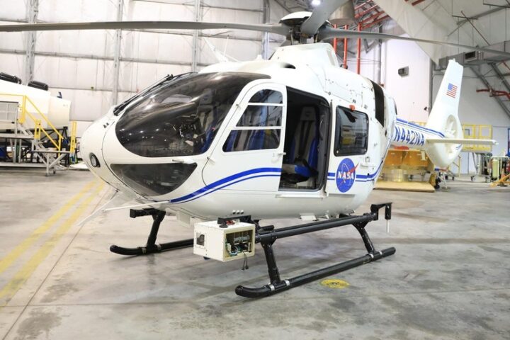 The NASA Airborne Instrumentation for Real-world Video of Urban Environments (AIRVUE) sensor pod is attached to the base of a NASA helicopter at NASA’s Kennedy Space Center in Florida in April 2024 before a flight to test the pod’s cameras and sensors. The AIRVUE pod will be used to collect data for autonomous aircraft like air taxis, drones, or other Advanced Air Mobility aircraft.