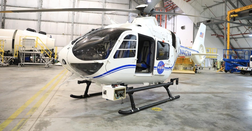 The NASA Airborne Instrumentation for Real-world Video of Urban Environments (AIRVUE) sensor pod is attached to the base of a NASA helicopter at NASA’s Kennedy Space Center in Florida in April 2024 before a flight to test the pod’s cameras and sensors. The AIRVUE pod will be used to collect data for autonomous aircraft like air taxis, drones, or other Advanced Air Mobility aircraft.