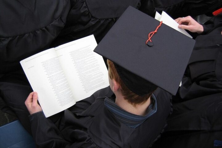 Student is sitting and reading book.