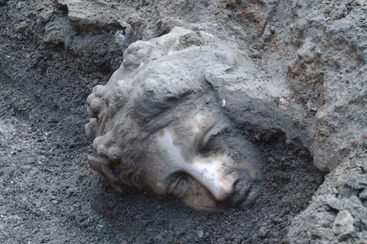 A face from history. A haunting sight at the archaeological site. The face of a statue of the god Dionysus as it's painstakingly chipped away from and brushed free of millennia of built-up deposits.