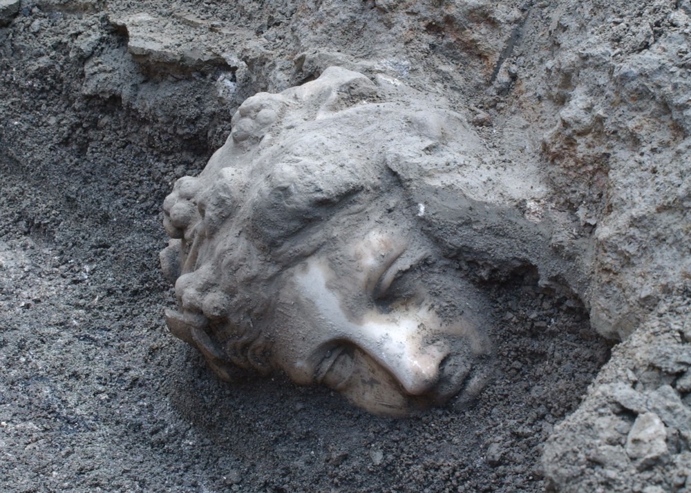 A face from history. A haunting sight at the archaeological site. The face of a statue of the god Dionysus as it's painstakingly chipped away from and brushed free of millennia of built-up deposits.