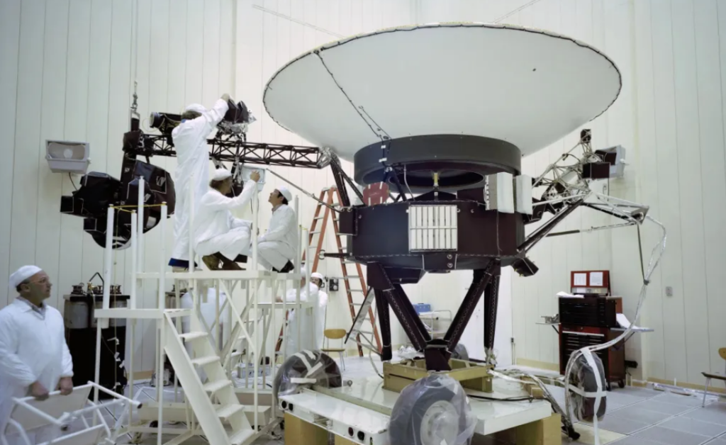 Engineers work on NASA’s Voyager 2 at JPL in March 1977, ahead of the spacecraft’s launch that August. The probe carries 10 science instruments, some of which have been turned off over the years to save power.