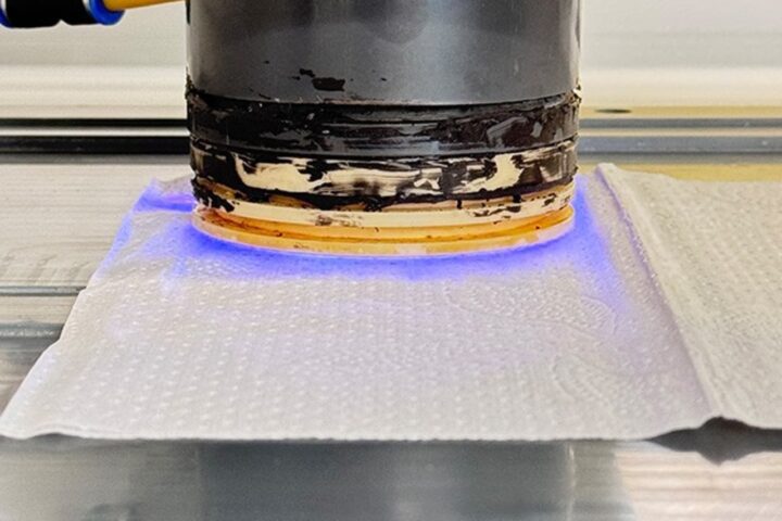 The plasma source is introduced close to the paper’s surface. The image shows the direct interaction of the plasma with the paper.