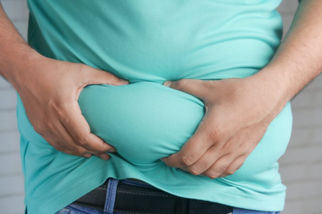 Representative Image. A Person Holding his Belly Fat. Photo Source: Towfiqu barbhuiya (Pexels)