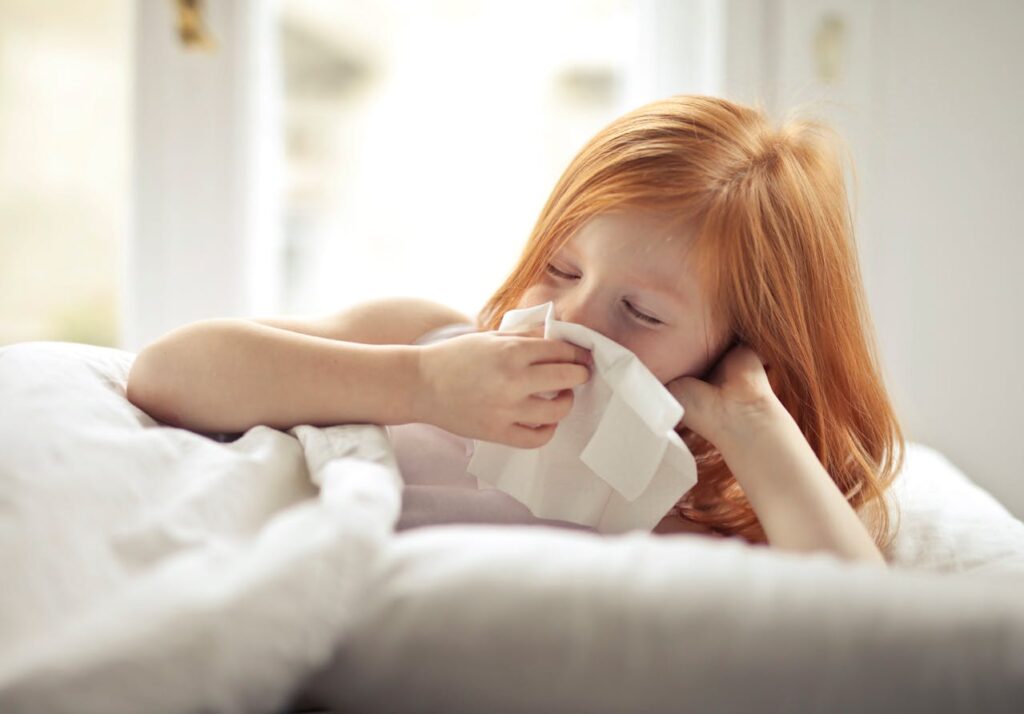 Representative Image. A sick girl wiping her nose with tissue. Photo Source: Andrea Piacquadio (Pexels)