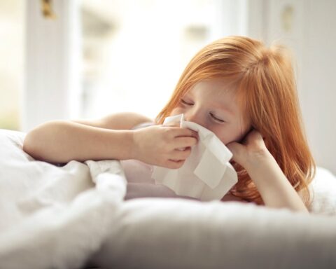 Representative Image. A sick girl wiping her nose with tissue. Photo Source: Andrea Piacquadio (Pexels)