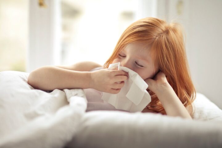 Representative Image. A sick girl wiping her nose with tissue. Photo Source: Andrea Piacquadio (Pexels)