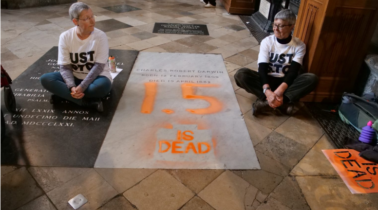 Two climate protesters painted Charles Darwin's grave orange to warn that Earth is getting dangerously hot.