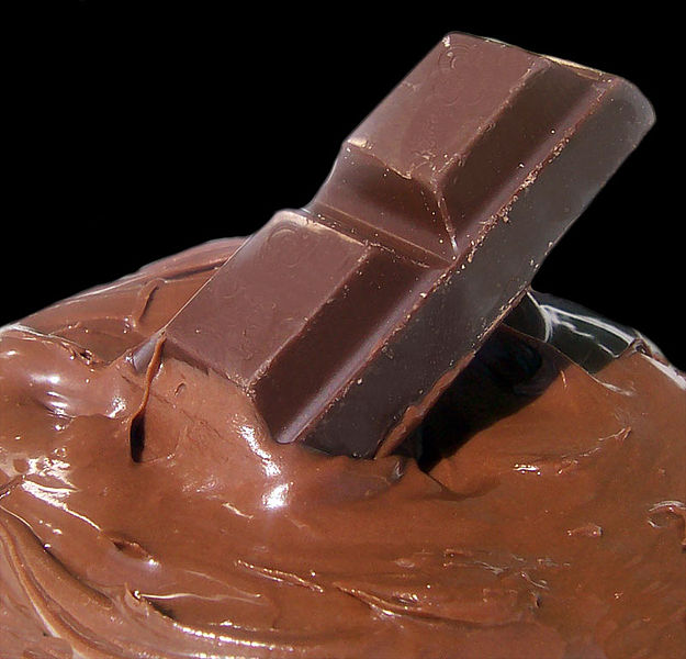 a piece of chocolate partially dipped in melted chocolate.