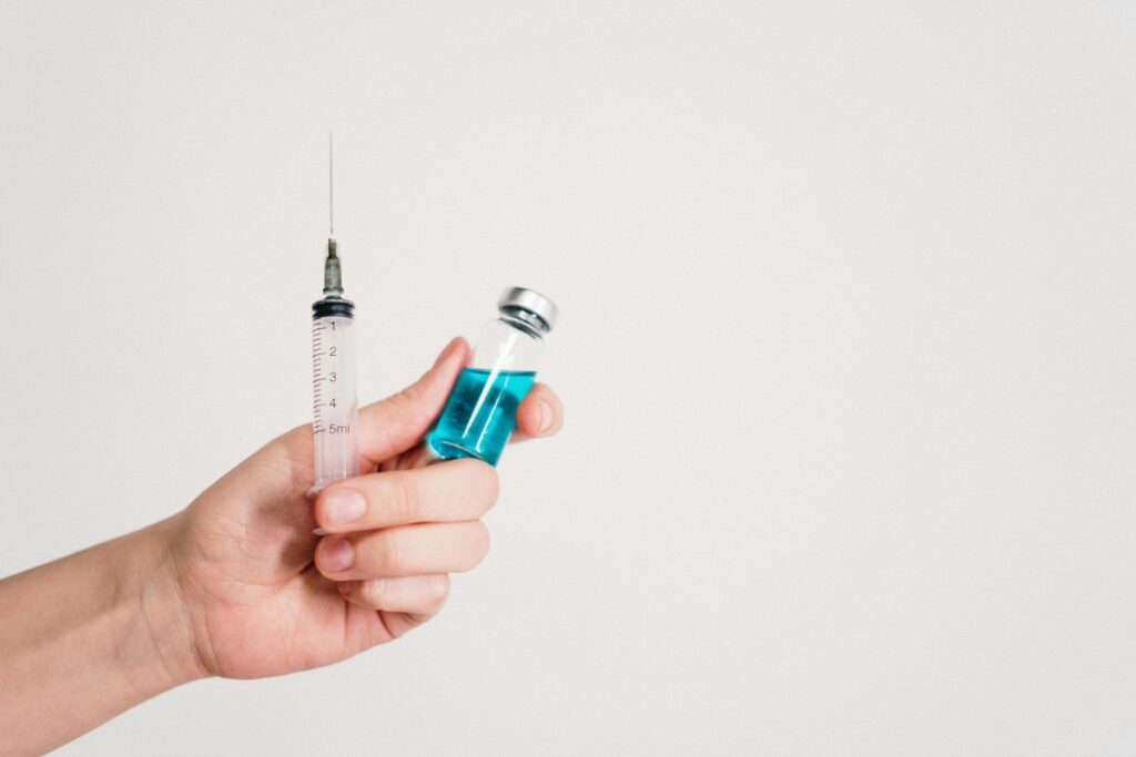 Representative Image. A Person is holding a syringe and a vaccine.(Source-Pexels)