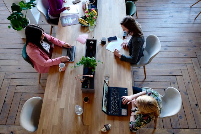 Reprentative Image. Three Woman Sitting on White Chair in Front of Table. Photo Source: Cowomen (Pexels)