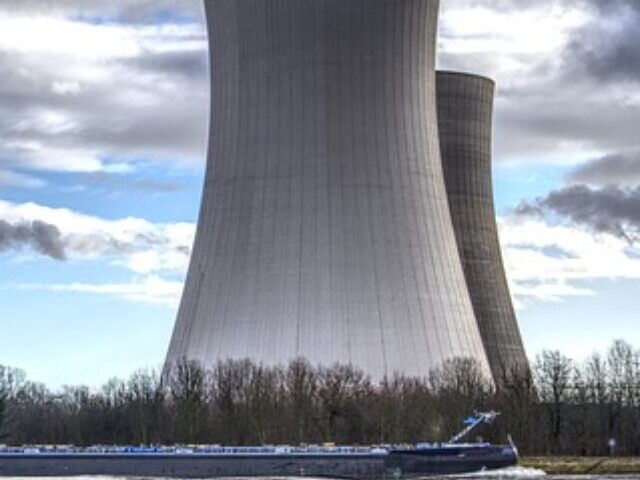 The image shows a large industrial structure, likely cooling towers of a power plant, Photo Source: Pixabay