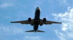 An airplane against a blue sky with clouds. Photo Source: xlibber (CC BY 2.0)