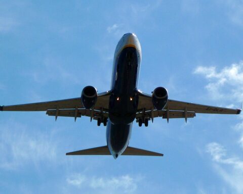 An airplane against a blue sky with clouds. Photo Source: xlibber (CC BY 2.0)