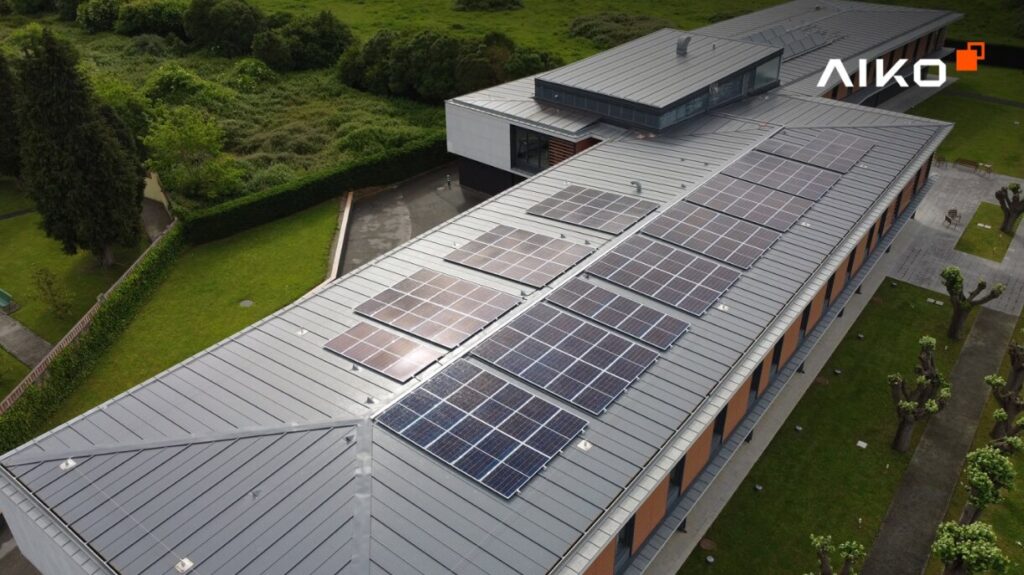 Modern building with a flat, metal roof adorned with numerous solar panels. Photo Source - Perth Solar Warehouse