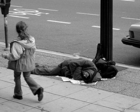 Man sleeping on Canadian sidewalk. Photo Source: The Blackbird (Jay Black) (CC BY-SA 2.0).