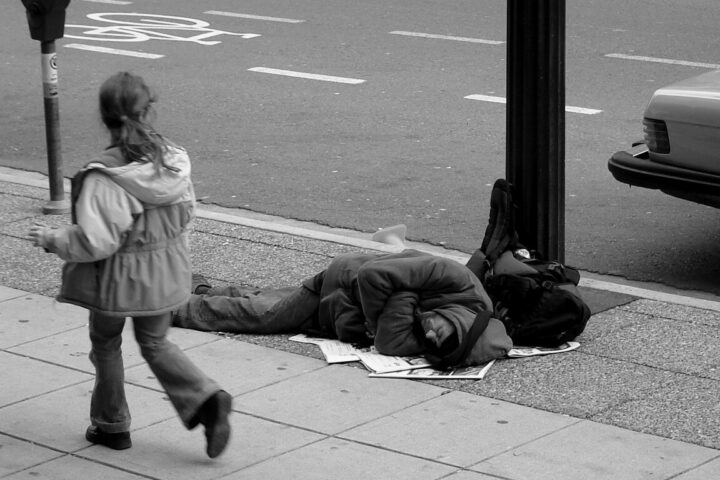 Man sleeping on Canadian sidewalk. Photo Source: The Blackbird (Jay Black) (CC BY-SA 2.0).