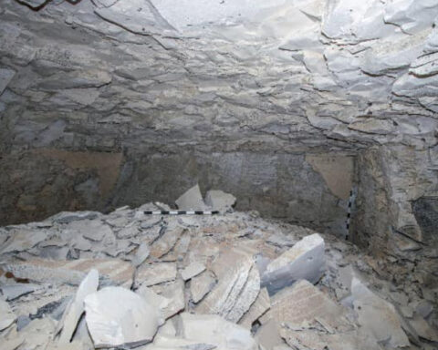 Rock-filled cave interior with measuring stick. Photo Source: Ministry of Tourism and Antiquities.