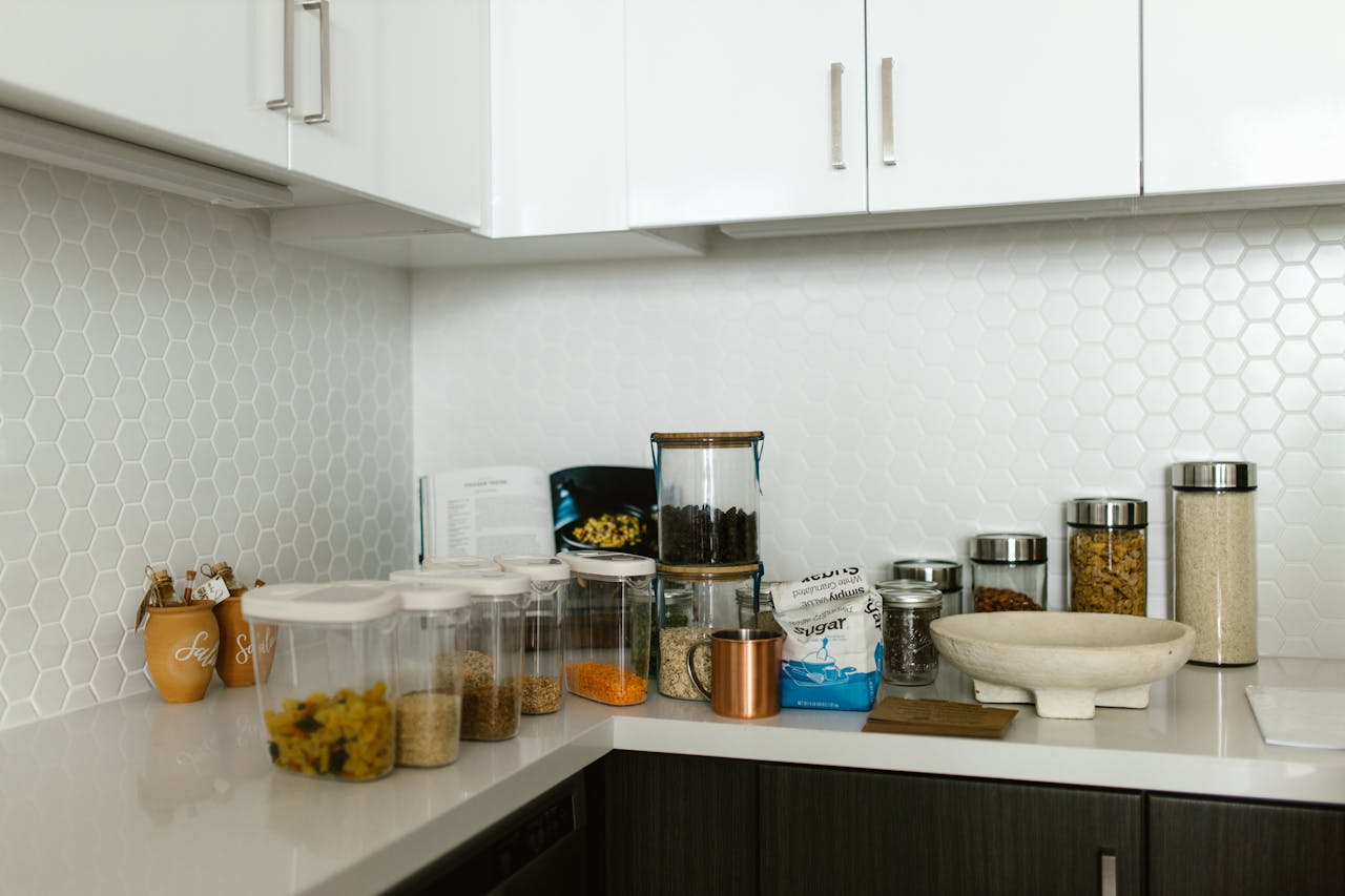 Representative Image. Clear Plastic Container and Glass Jars on a Kitchen Counter. Photo Source: RDNE Stock project (Pexels)