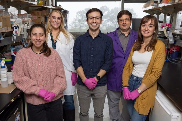 Five individuals standing in a laboratory setting. Photo Source - Salk Institute