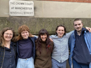 Group of five smiling people outside Manchester Crown Court. Photo Source: Just Stop Oil.