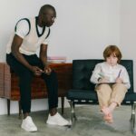 Representative Image: The image shows a man teaching a young boy in a minimalistic room. Photo Source: Mikhail Nilov (Pexels)