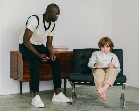 Representative Image: The image shows a man teaching a young boy in a minimalistic room. Photo Source: Mikhail Nilov (Pexels)