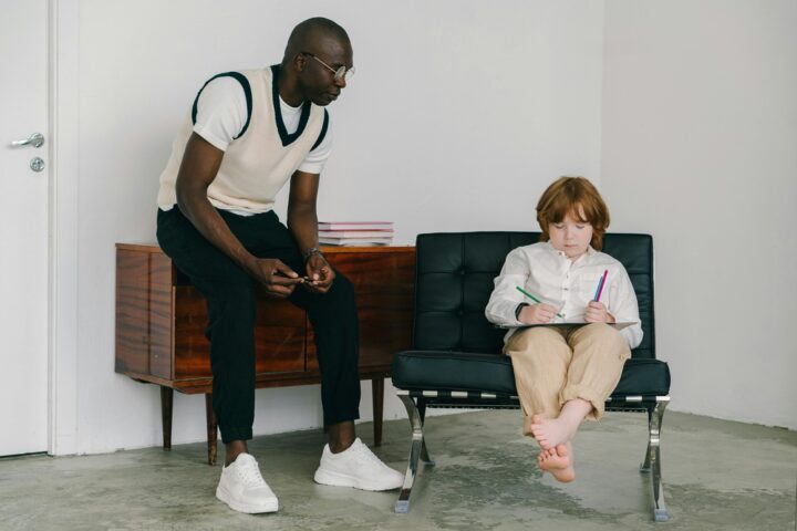 Representative Image: The image shows a man teaching a young boy in a minimalistic room. Photo Source: Mikhail Nilov (Pexels)