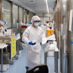 Representative Image. A medical or laboratory setting with individuals wearing full protective gear. Photo Source - Hospital Clinic (CC BY-ND 2.0)