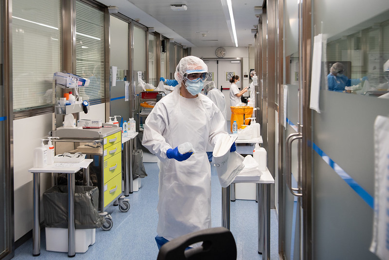 Representative Image. A medical or laboratory setting with individuals wearing full protective gear. Photo Source - Hospital Clinic (CC BY-ND 2.0)