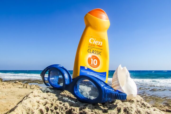 Representative image. Sunscreen, goggles, and seashell on a rocky beach. Photo Source: Dimitrisvetsikas1969 (Pixabay).