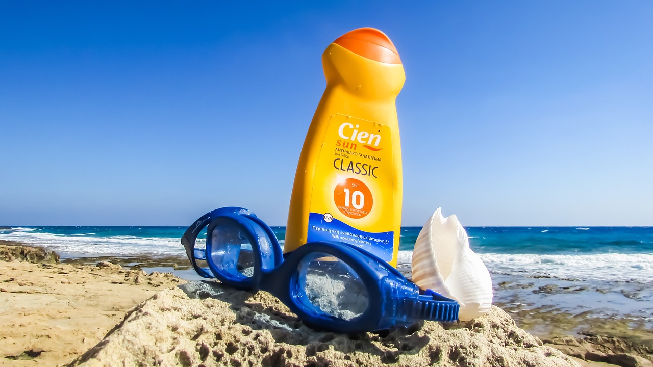 Representative image. Sunscreen, goggles, and seashell on a rocky beach. Photo Source: Dimitrisvetsikas1969 (Pixabay).