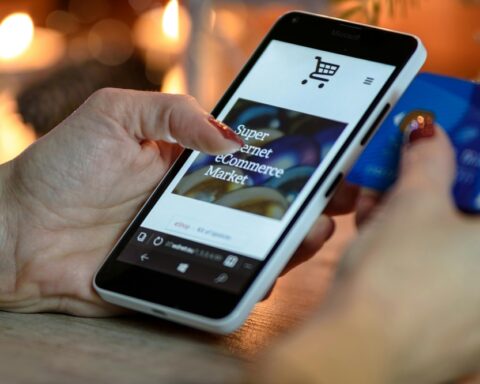 Representative image. Person Using Black And White Smartphone and Holding Blue Card. Photo Source: AS Photography