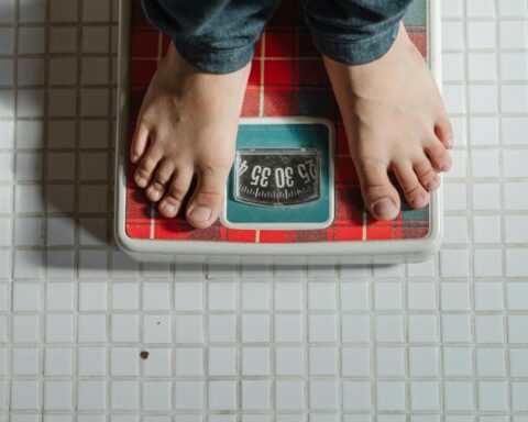 Representative Image. Crop kid weighing on scale. Photo Source: Ketut Subiyanto (Pexels)