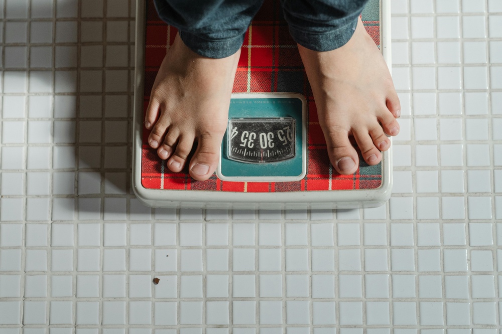 Representative Image. Crop kid weighing on scale. Photo Source: Ketut Subiyanto (Pexels)