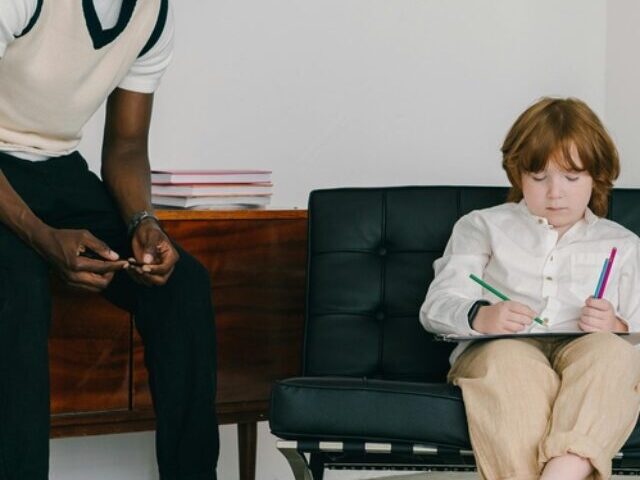 Representative Image: The image shows a man teaching a young boy in a minimalistic room. Photo Source: Mikhail Nilov (Pexels)