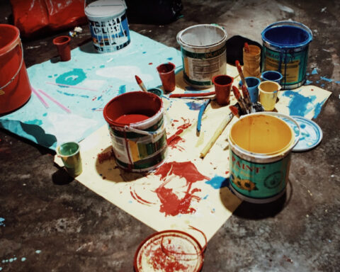 Representative Image. A cluttered workspace with an assortment of paint cans. Photo Source - Pxhere