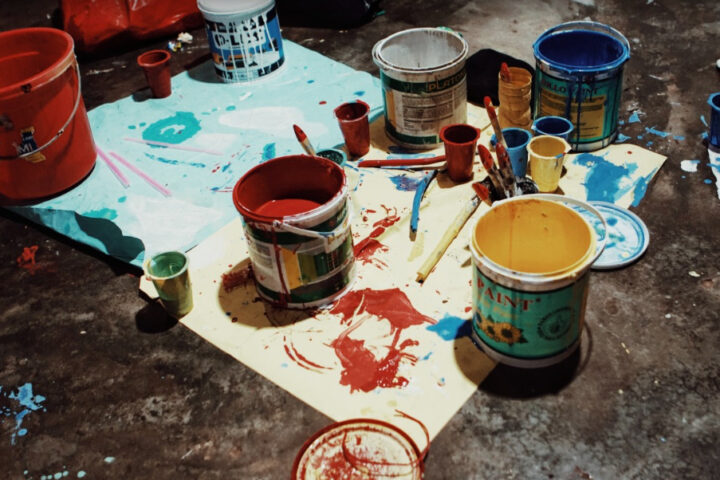 Representative Image. A cluttered workspace with an assortment of paint cans. Photo Source - Pxhere