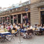 Representative Image. A bustling outdoor café scene. Photo Source - David Hawgood (CC BY-SA 2.0)