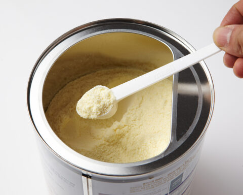 Representative Image. A hand holding a white plastic scoop filled with powdered formula. Photo Source - 국립국어원 (CC BY-SA 2.0 KR)