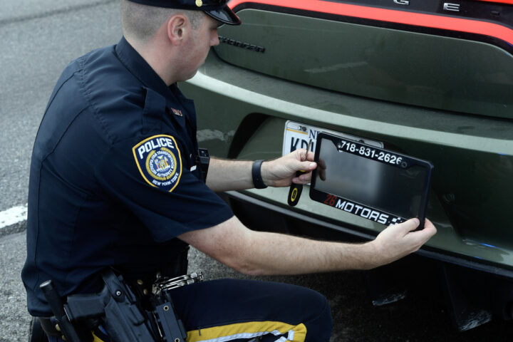 Police Officer remove the Ghost Car number Frame. Photo source: MTA