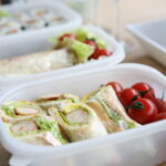 Representative Image: two white plastic containers with sandwich and tomatoes.